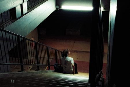 a person sitting on the steps of a building at night