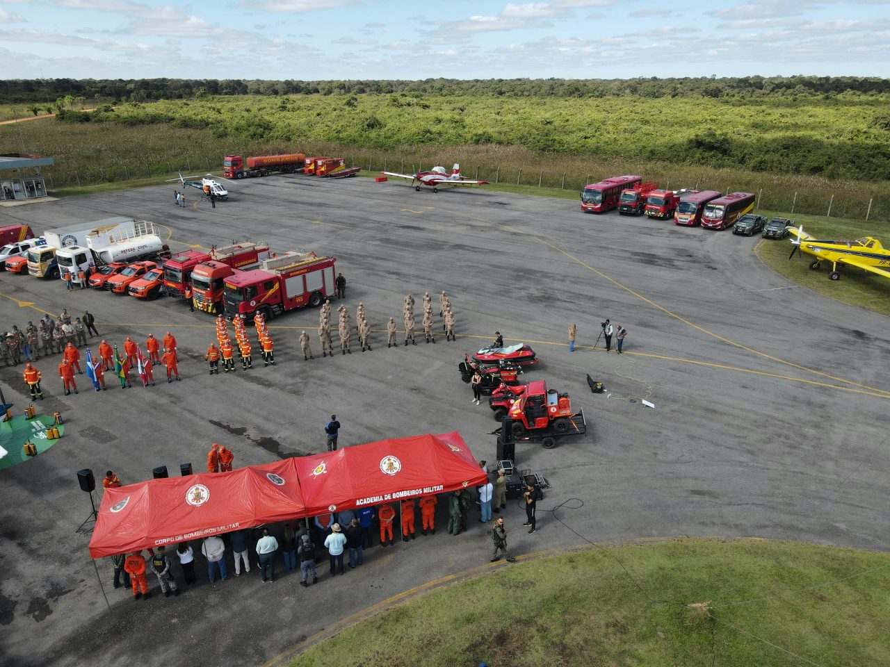 Aerial view of firefighter training with vehicles, tents, and personnel outdoors.